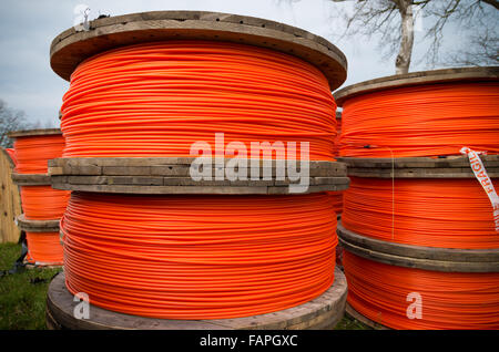 große Trommeln mit orange Glasfaserkabel auf einer Baustelle Stockfoto