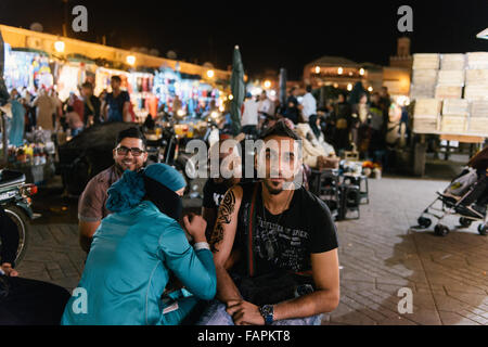 Tourist, Henna Tätowierung am Unterarm in Jemaa el Fna Platz in Marrakesch in der Nacht Stockfoto