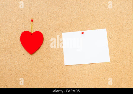 Rote Herzen und weißen leeren Valentinstagskarte angeheftet auf hölzernen Pinnwand Stockfoto