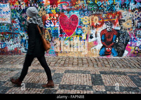 Eine Mädchen geht vorbei an der John-Lennon-Mauer im Zentrum von Prag. Die John-Lennon-Mauer ist eine Mauer, die einst einen Großteil der könnte Stockfoto
