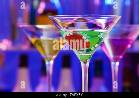 Casino-Chip in Cocktailgläser mit Bar auf Rückseite Stockfoto