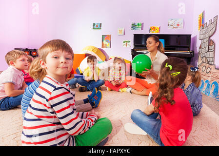 Kinder und Lehrer sitzen im Kreis Stockfoto