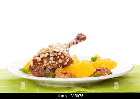 Kulinarischen gebratene Ente mit Orangen und Nüssen auf Platte isoliert auf weißem Hintergrund. Leckere festliche Essen. Stockfoto