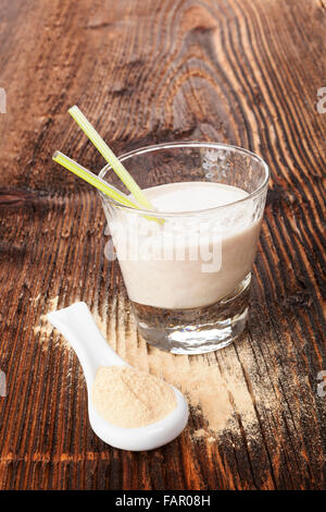 Maca Pulver auf Löffel und Maca Pulver schütteln auf braun alter Holztisch. Gesundes Wohnen, alternative Medizin, rustikalen Stil. Stockfoto