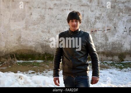 LÖKBATAN, Aserbaidschan - 8. Februar 2014 hübscher junger Mann ist daran interessiert, posieren für ein Bild trägt eine schwarze Lederjacke Stockfoto