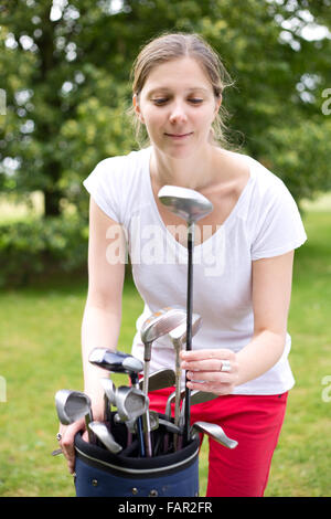 junge Frau, die Kommissionierung ihrer Golf club Stockfoto