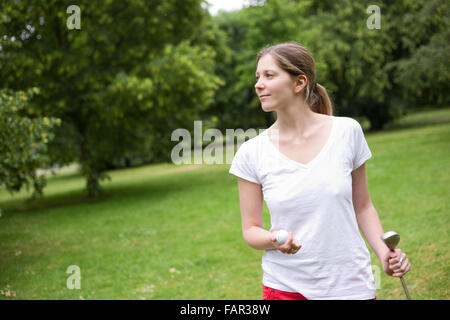 ein Porträt einer jungen Frau auf dem Golfplatz Stockfoto