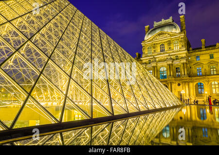 Louvre Museum-Haupteingang und Brunnen in der Abenddämmerung, Paris Stockfoto