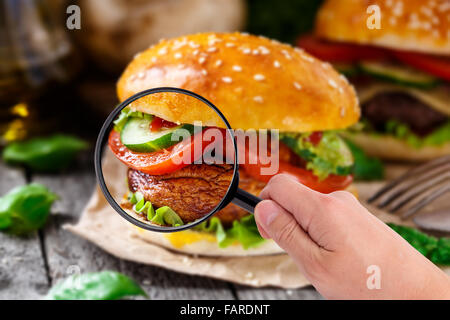 Lupe untersuchen burger Stockfoto