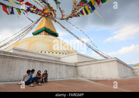 Junge Leute sitzen und reden in Boudhanath Stupa. Kathmandu. Nepal. Stockfoto