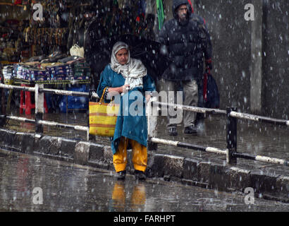 Srinagar, indische verabreicht Kaschmir. 4. Januar 2015. Kashmiri Frau geht auf der Straße während fallende Kaschmir-Tal erhielt Neuschnee heute. Die höheren Reichweiten des Kaschmir-Tal erhalten mehr Schnee als viele Bereiche in den Ebenen. Die MeT-Abteilung hat vorausgesagt, mäßiger Regen und Schnee in Kaschmir für heute und morgen Credit: Sofi Suhail/Alamy Live News Stockfoto