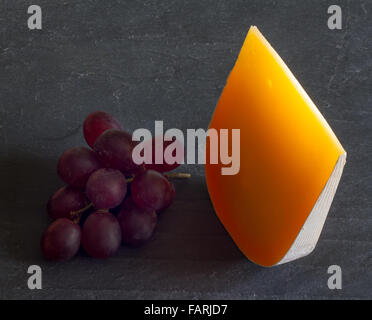 Gelben Stück Käse abstrakte Stilleben mit Trauben closeup Stockfoto