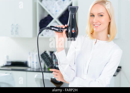 Stylist mit Fön und Bürste. Stockfoto