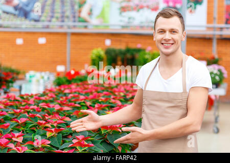 Lächelnd Florist demonstrierende Blume Vielfalt. Stockfoto