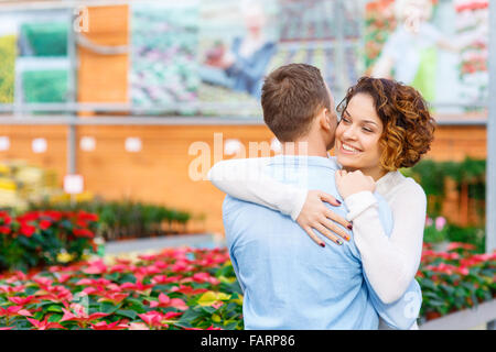 Schönes paar umarmt im Gewächshaus. Stockfoto