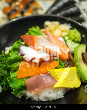 Eine Schüssel mit Chirashi (Chirashizushi), bestehend aus Sushi-Reis, garniert mit einer Vielzahl von rohem Fisch und Gemüse. Stockfoto