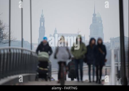 Dresden, Deutschland. 3. Januar 2016. Fußgänger überqueren eine Fußgängerbrücke, vor Gericht mit dem historischen Stadtteil einschließlich der katholischen Kirche (L-R), der Palast-Turm und dem Rathausturm im Bild im Hintergrund, in Dresden, Deutschland, 3. Januar 2016. Foto: SEBASTIAN KAHNERT/Dpa/Alamy Live News Stockfoto