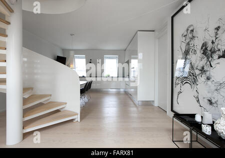 No-Nonsense, moderne Wohnung in Kopenhagen. Weiße Wände und einen Holzboden. Kunstwerke und minimalistischen Stil. Wendeltreppe. Stockfoto