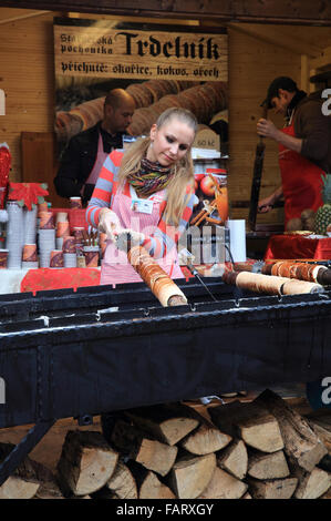 Kochen und verkaufen "trdelník", die traditionelle tschechische Kuchen und süßem Gebäck auf dem Weihnachtsmarkt auf der Prager Burg Stockfoto