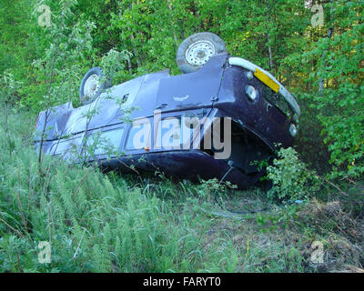 Das Auto, das in einem Graben infolge Unfalls nach unten verschoben. Das gedrehte Auto. Stockfoto