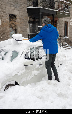 Mann, Schaufeln und Beseitigung von Schnee vom Auto in Montreal, Kanada, 30. Dezember 2015. Stockfoto