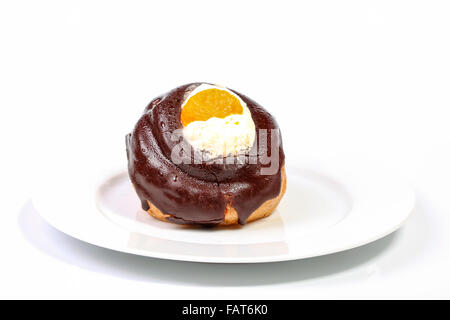 Schokolade überdachten Profiterole mit Schlagsahne auf einem Teller Stockfoto