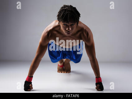 Junge muskulöse athletische männliche Boxer blaue Boxershorts und rote Boxhandschuhe. Stockfoto