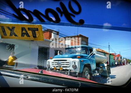 Kubanische Straßenansicht von entgegenkommenden LKW in Trinidad, durch eine alte Vintage Ford Taxi Windschutzscheibe Stockfoto