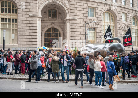 Touristen aller cluster und posieren für Fotos vor der Wall Street Bull, vom Künstler Arturo DiModica, am Broadway in Lower Manhattan in New York auf Freitag, 25. Dezember 2015. (© Richard B. Levine) Stockfoto