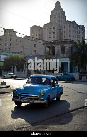 blauer Oldtimer und Passagiere fahren vom Hotel Nacional, wie die Sonne in Havanna, Kuba untergeht Stockfoto