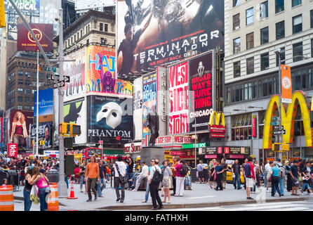 Touristen und Besucher erleben Sie die Sehenswürdigkeiten in der Nähe von der Statur des George M. Cohan in Duffy Square in Times Square in New York City. Stockfoto