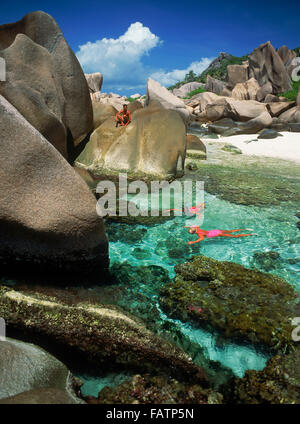 Touristen, die Schnorcheln im Gezeiten-Pools auf der Insel La Digue auf den Seychellen Stockfoto