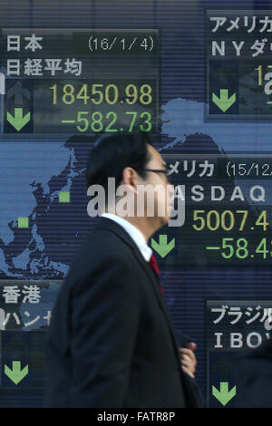 Tokio, Japan. 4. Januar 2016. Ein Mann geht über eine elektronische Schild mit Japans Nikkei stock Durchschnitt (oben links) am ersten Tag des Geschäftsjahres 2016 in Tokio, Japan, 4. Januar 2016. © Yuriko Nakao/AFLO/Alamy Live-Nachrichten Stockfoto