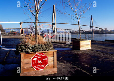 Westminster Pier Park entlang Fraser River, New Westminster, British Columbia, Kanada - Skybridge und Patullo Brücke in Ferne Stockfoto