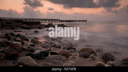 Seelandschaft mit Badesteg während einer dramatischen bewölkten Sonnenuntergang auf Paphos in Zypern Stockfoto