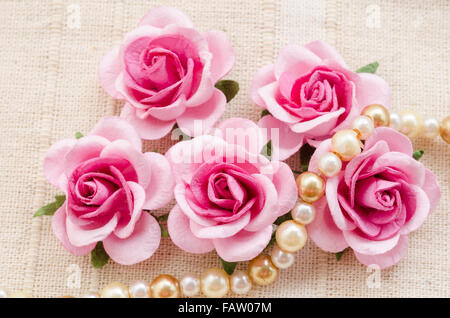 Rosa Rose mit Perlen auf Stoff Hintergrund. Stockfoto