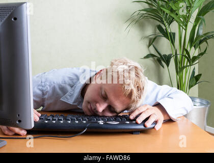 Müde Mann gefallen schlief über die Tastatur des Computers bei der Arbeit im Büro Model Release: Ja eingebrochen. Property Release: Nein. Stockfoto