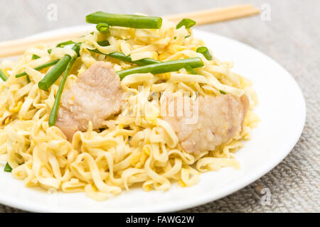 Pork Chow Mein mit Stäbchen in weißen Teller. Stockfoto