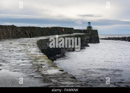 Hafenmauer mit Leuchtturm am Ende in das hübsche Fischerdorf Dorf Pittenweem auf der Küste von Fife, Schottland Stockfoto
