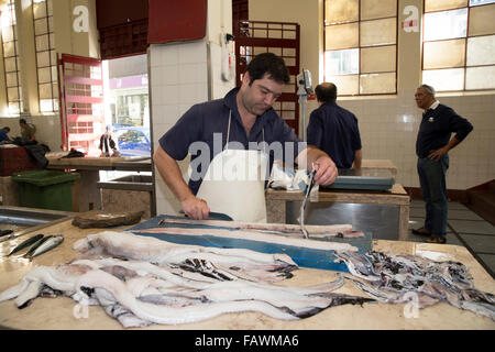 Fischhändler ausnehmen von Fisch auf dem öffentlichen Markt in Madeira Stockfoto