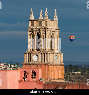 Turmuhr und Glocken der Pfarrkirche mit einer Ballonfahrt in der Ferne; San Miguel de Allende, Guanajuato, Mexiko Stockfoto