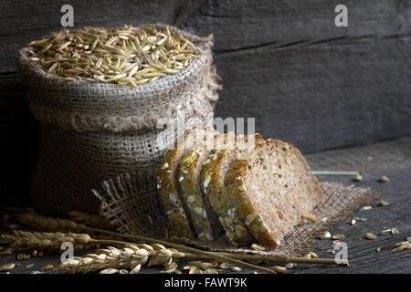 Brot und Getreide in der Tasche auf einem Vintage Holzbrettern Stockfoto