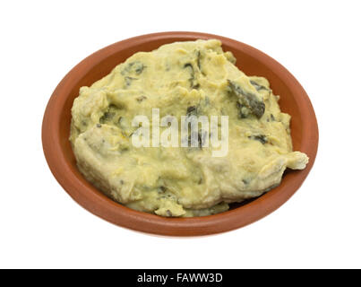 Eine Portion frisch verpackten Spinat Hummus in einer kleinen Schüssel isoliert auf einem weißen Hintergrund. Stockfoto