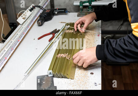 Mann arbeitet auf Montage der Jalousie zu Hause Workshop. Stockfoto