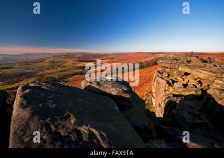 Kletterer auf in der Nähe von Robin Hoods Höhle auf Stanage Edge während einem hell, aber kalten Wintertag im Peak District National Park Stockfoto