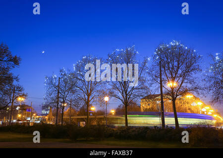 Die Beleuchtung an Bäumen zur Adventszeit am Hauptbahnhof mit Straßenbahn vorbei in Zagreb, Kroatien. Stockfoto