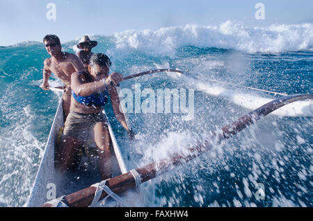 Big Island, Hawaii, Mauna Lani, South Kohala Coast, Surfen, Kanu, Weiblich & zwei Männchen fangen Welle Kohala Küste, Mauna Lani Stockfoto