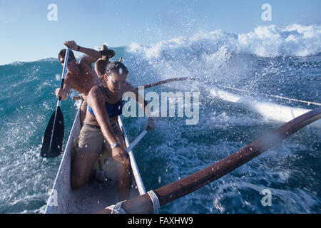 Big Island, Hawaii, Mauna Lani, South Kohala Coast, Surfen, Kanu, Weiblich & zwei Männchen fangen Welle Kohala Küste, Mauna Lani Stockfoto