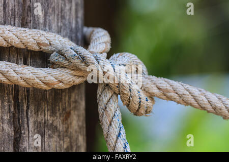 Closeup-Knoten der dicken Seil um einen hölzernen Pfahl gebunden Stockfoto