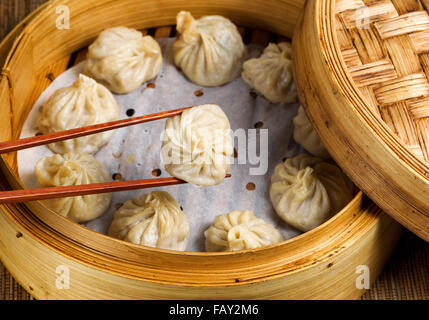 Nahaufnahme von chinesische gedämpfte Knödel, selektiven Fokus auf Stück statt in Stäbchen aus Bambus Dampfgarer Stockfoto